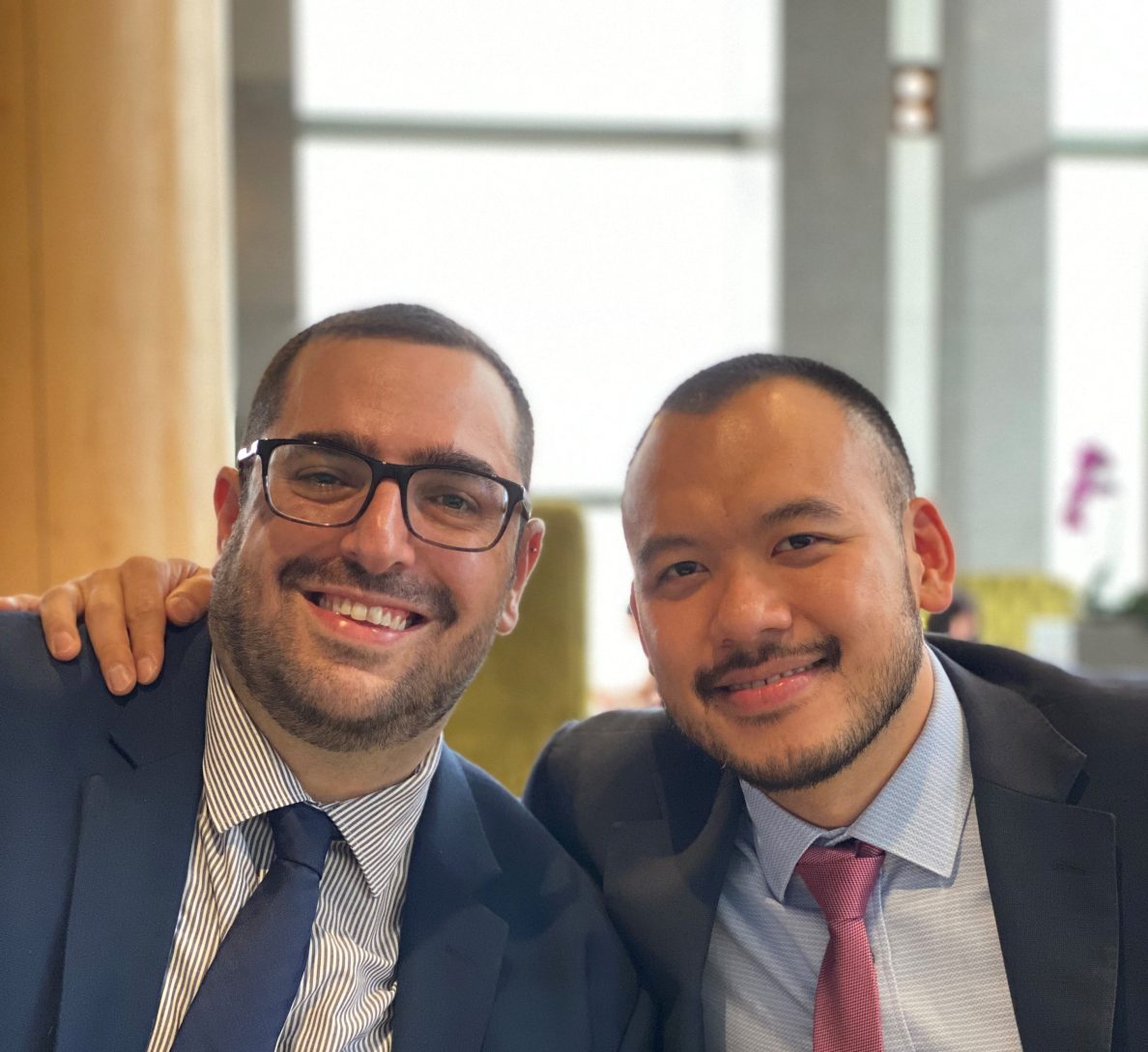 Two men in suit smiling